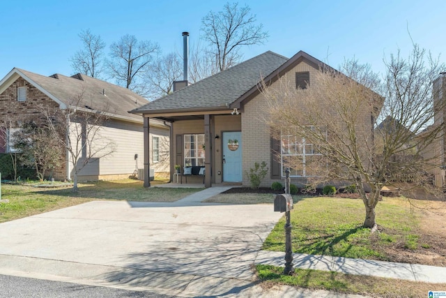 view of front of home featuring brick siding, roof with shingles, and a front yard