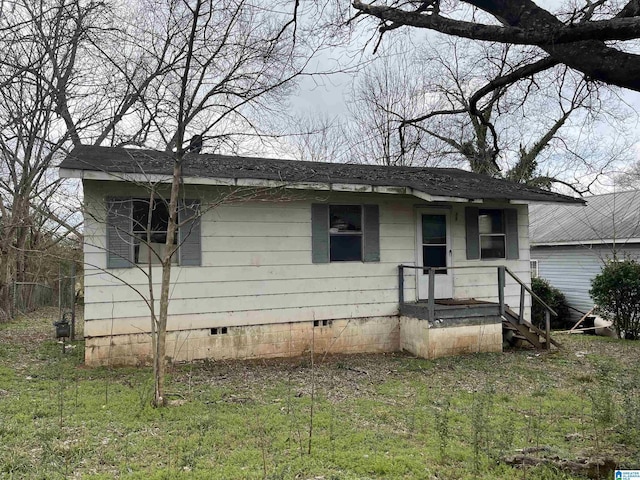 view of front of house featuring a front yard, crawl space, and roof with shingles