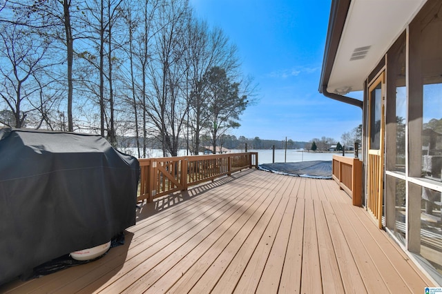 wooden terrace featuring visible vents and area for grilling