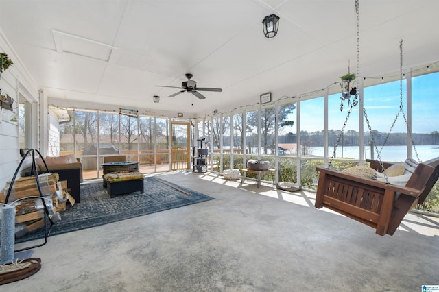 sunroom / solarium with a water view, a ceiling fan, and a healthy amount of sunlight