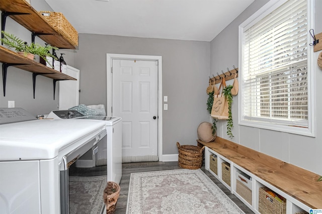 clothes washing area featuring laundry area, baseboards, washer and clothes dryer, and wood finished floors