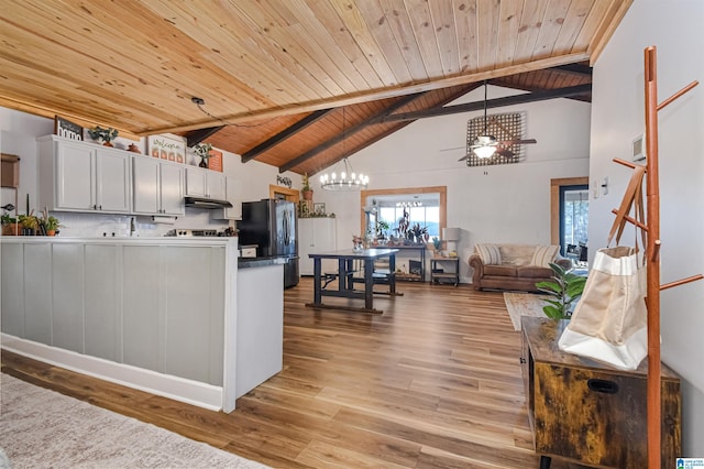 kitchen featuring wooden ceiling, beamed ceiling, freestanding refrigerator, light wood-type flooring, and under cabinet range hood