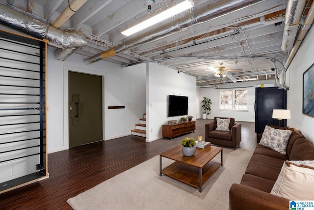 living area featuring stairway, baseboards, and wood finished floors