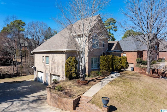 view of front of home featuring driveway, an attached garage, a shingled roof, and a front yard