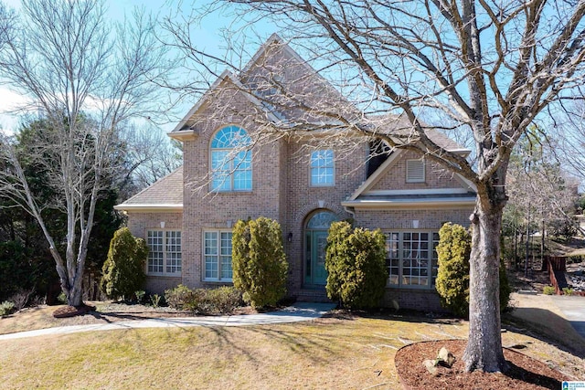 view of front of property featuring a front yard and brick siding