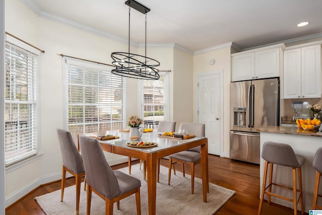 dining room featuring ornamental molding, dark wood-style flooring, and a wealth of natural light