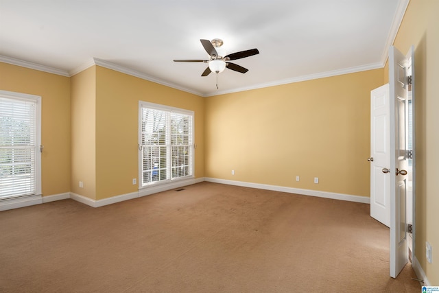 unfurnished room featuring visible vents, ornamental molding, a ceiling fan, light carpet, and baseboards