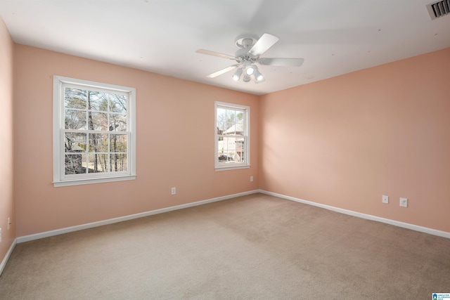 spare room featuring a ceiling fan, carpet, visible vents, and baseboards