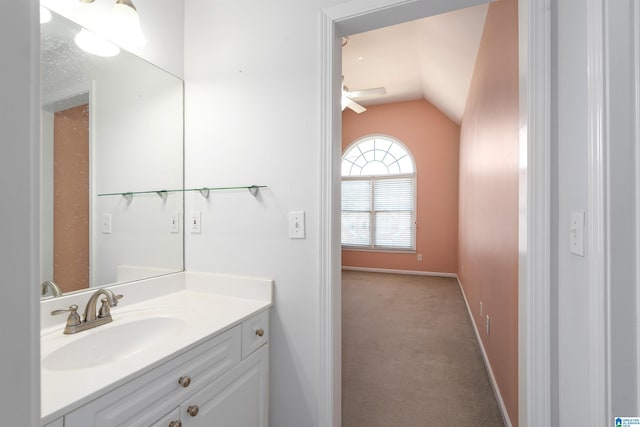 bathroom with baseboards, vaulted ceiling, and vanity