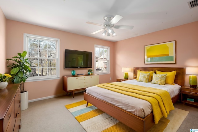 bedroom featuring light colored carpet, visible vents, ceiling fan, and baseboards