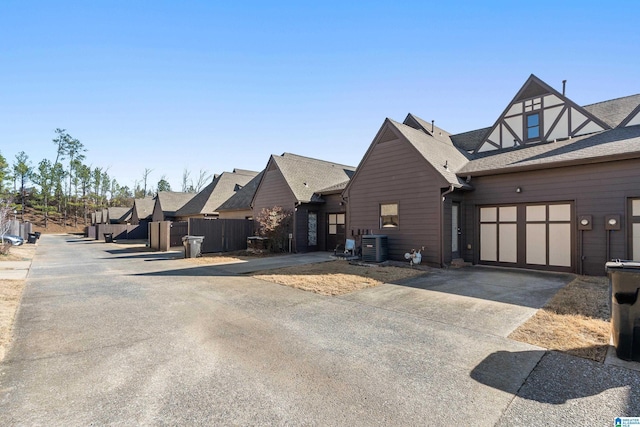 view of front of house featuring a garage, concrete driveway, and cooling unit