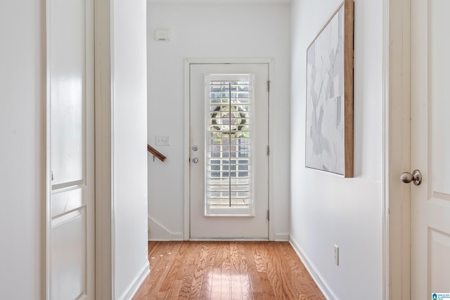 doorway featuring baseboards and light wood-style floors