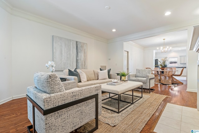 living room with ornamental molding, wood finished floors, and an inviting chandelier