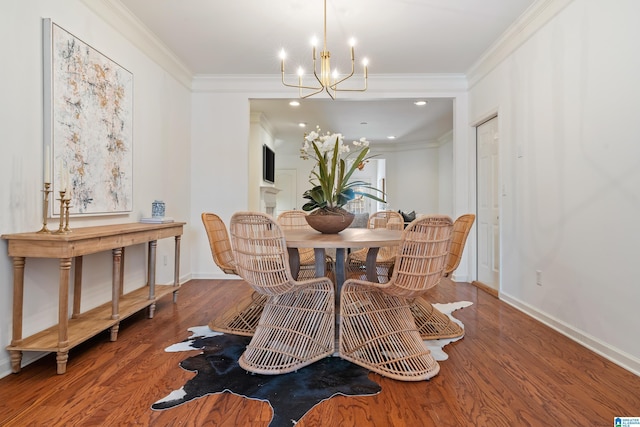 dining area featuring a chandelier, ornamental molding, baseboards, and wood finished floors