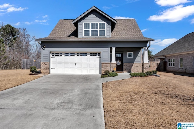 craftsman inspired home featuring brick siding, fence, driveway, and a front lawn