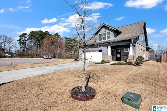 view of front of house featuring brick siding, a shingled roof, an attached garage, fence, and driveway