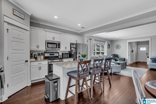 kitchen with white cabinets, a center island, stainless steel appliances, and open floor plan