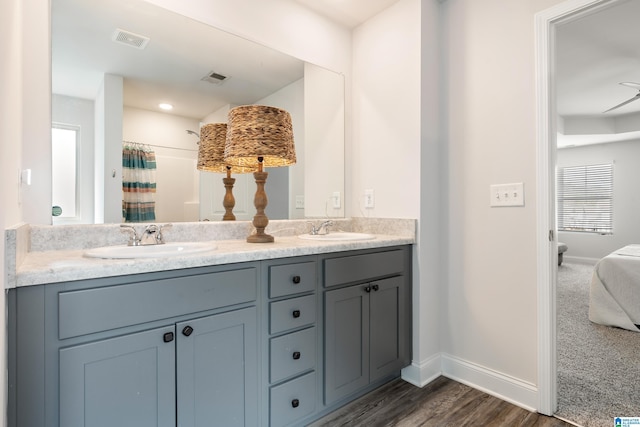 bathroom with double vanity, visible vents, baseboards, and a sink