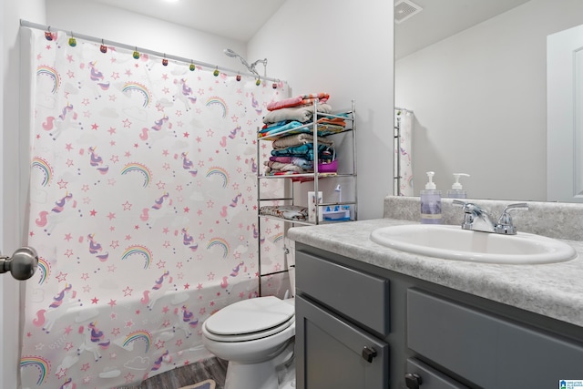 bathroom with vanity, wood finished floors, shower / bathtub combination with curtain, visible vents, and toilet