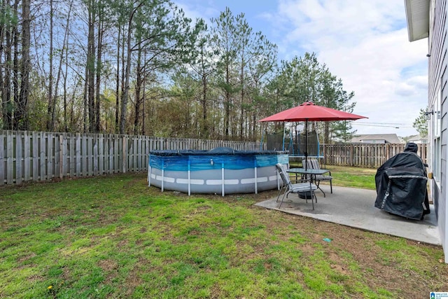 view of pool with a patio area, a yard, a fenced in pool, and a fenced backyard