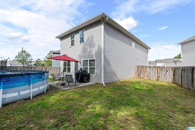 back of house with a yard, a patio, a fenced in pool, and a fenced backyard