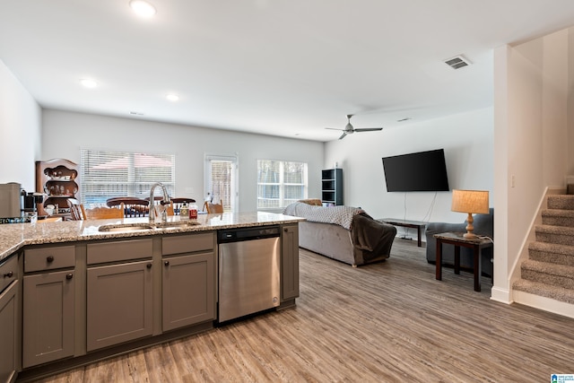 kitchen featuring visible vents, gray cabinetry, a sink, stainless steel dishwasher, and a wealth of natural light