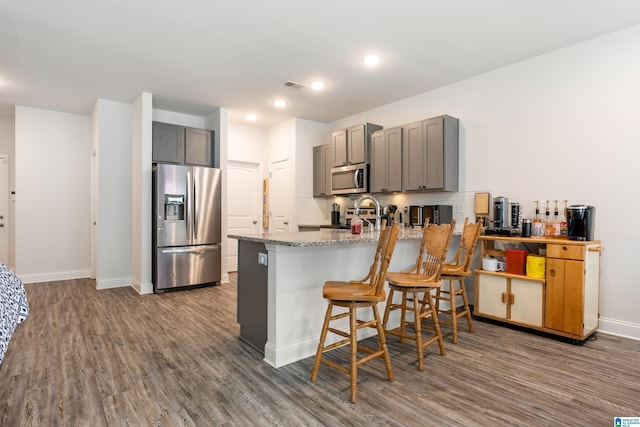 kitchen with visible vents, decorative backsplash, gray cabinets, a peninsula, and stainless steel appliances