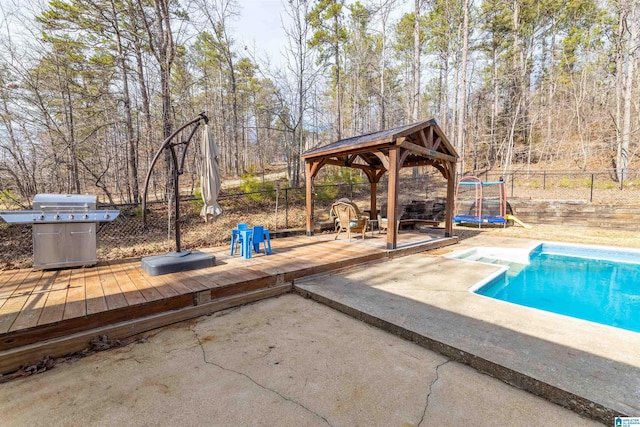 view of pool with a fenced in pool, a fenced backyard, a trampoline, a deck, and a gazebo