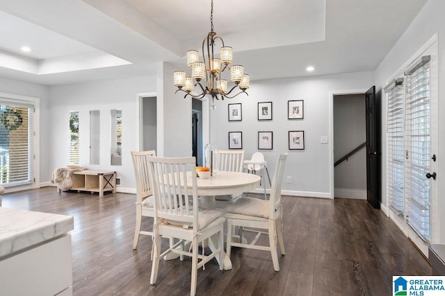 dining space with a tray ceiling, dark wood-style flooring, baseboards, and recessed lighting