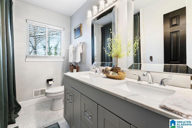 full bath featuring toilet, double vanity, a sink, and visible vents