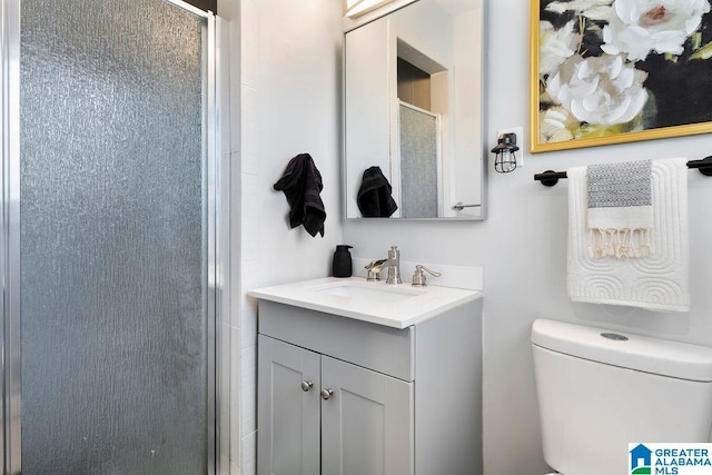 full bath featuring toilet, a shower with shower door, and vanity