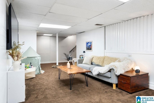 living area featuring baseboards, visible vents, dark colored carpet, and a drop ceiling