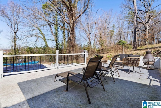 view of patio featuring fence and a pool