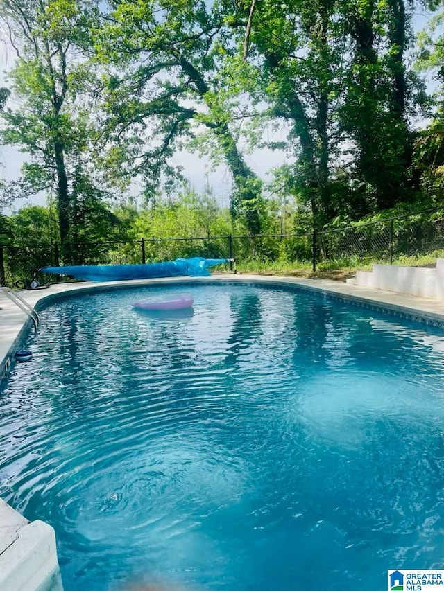 view of swimming pool with a fenced in pool and fence