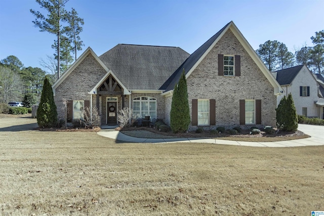 view of front of home with brick siding and a front lawn