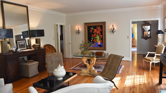 living area with light wood-style floors, ornamental molding, and baseboards