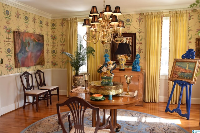 living area with wallpapered walls, crown molding, wood finished floors, and an inviting chandelier