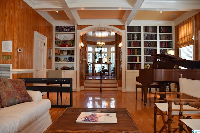 interior space with beam ceiling, a notable chandelier, visible vents, wood finished floors, and coffered ceiling