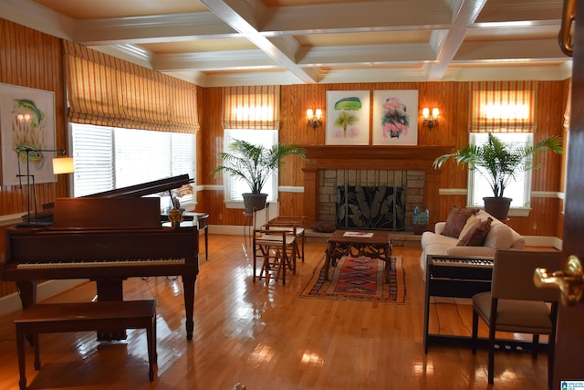 living area with a healthy amount of sunlight, a fireplace, coffered ceiling, and wood finished floors