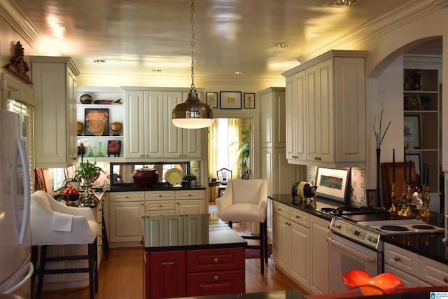 kitchen with dark countertops, stainless steel refrigerator, a center island, hanging light fixtures, and white electric range