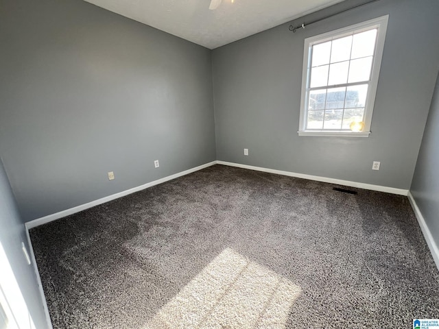 carpeted empty room featuring ceiling fan and baseboards