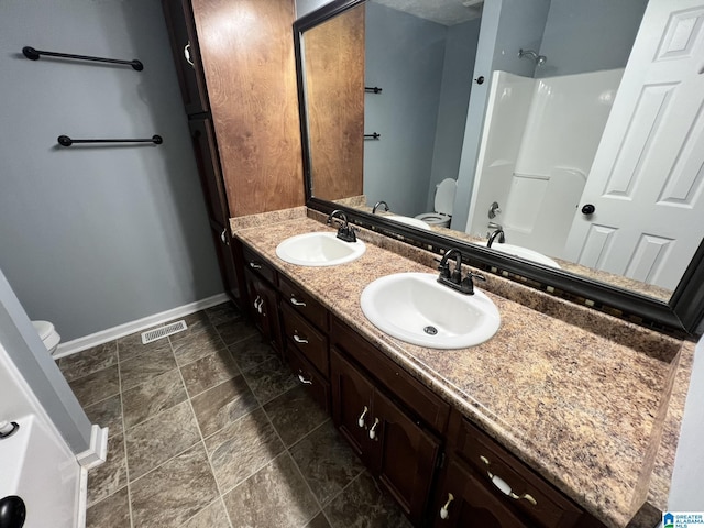 bathroom with visible vents, a sink, toilet, and baseboards