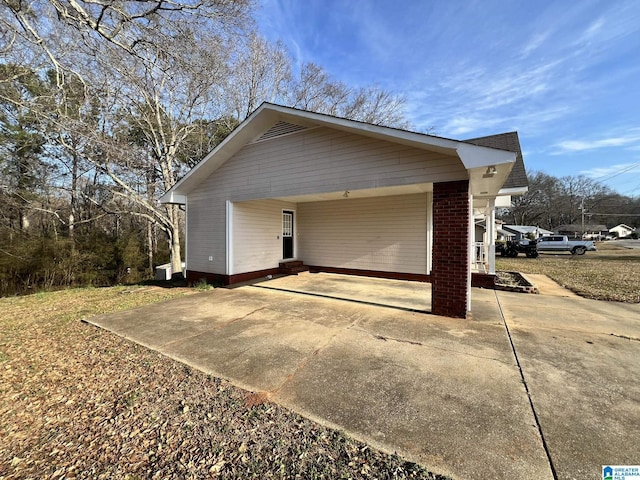 garage featuring a carport and concrete driveway