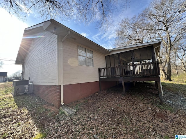 view of property exterior featuring a sunroom and central AC