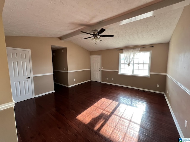 empty room with vaulted ceiling with beams, hardwood / wood-style floors, a textured ceiling, and baseboards