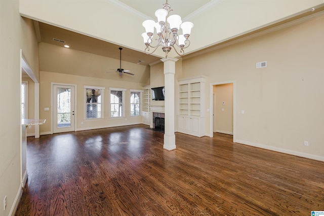 unfurnished living room featuring a fireplace, visible vents, dark wood-type flooring, ornamental molding, and ceiling fan with notable chandelier