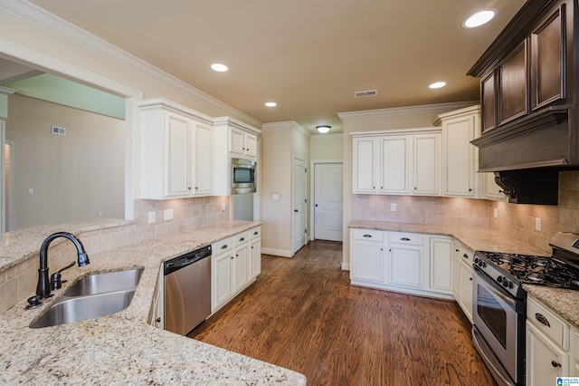 kitchen featuring crown molding, appliances with stainless steel finishes, dark wood-type flooring, a sink, and light stone countertops