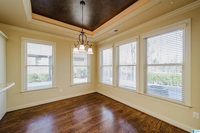 unfurnished dining area with a tray ceiling, dark wood-type flooring, visible vents, and crown molding