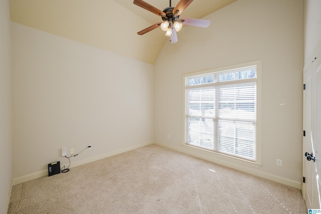 carpeted spare room featuring lofted ceiling, baseboards, and a ceiling fan