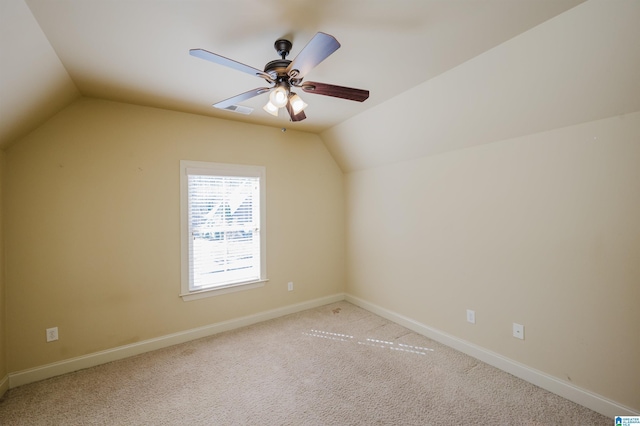 additional living space with light carpet, visible vents, baseboards, a ceiling fan, and vaulted ceiling